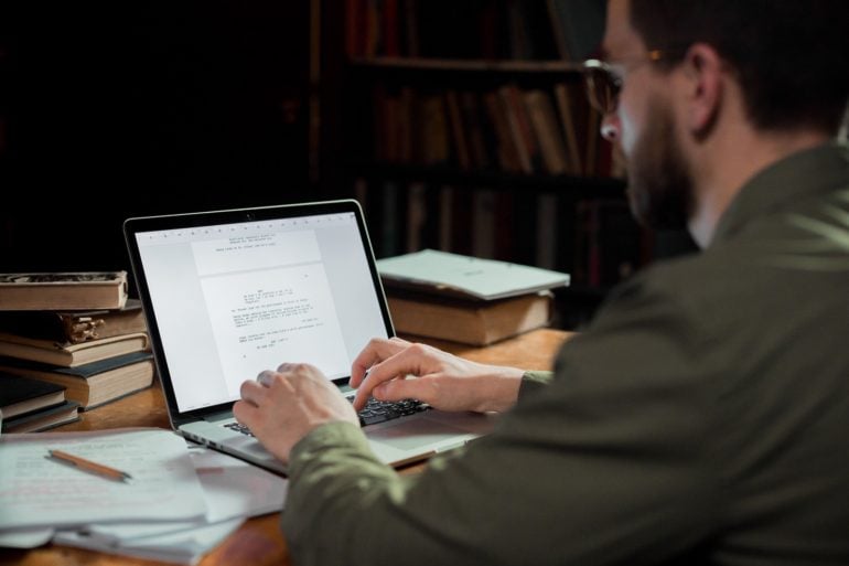 Man typing on a laptop at a desk